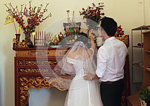 Grandfather with bride and groom are burned incense to forefather in wedding day