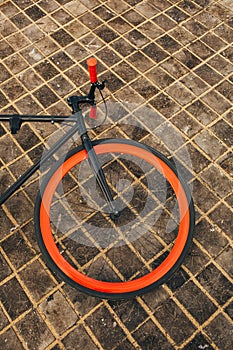 One wheel of red bycicle on floor