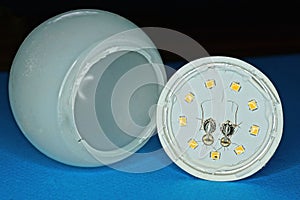 One white disassembled plastic led light bulb with a yellow diodes