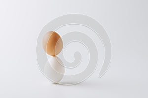 one white and one brown eggs stacked