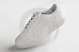 One white sneaker on a light background. Sports shoes for running close-up.