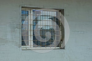 One white square window behind an iron bars