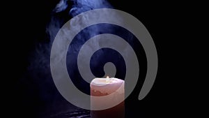 One White Wax Candle Burning in a Cloud of Thick Blue Smoke on Black Background