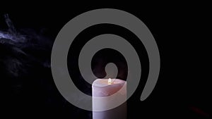 One White Wax Candle Burning in a Cloud of Thick Smoke on a Black Background
