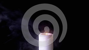 One White Wax Candle Burning in a Cloud of Thick Smoke on a Black Background