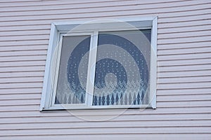 White window on a light pink plastic wall