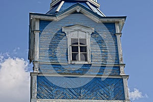 One white window on the old blue wooden loft of the church