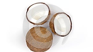 One whole coconut and two halves with yummy pulp rotating on white background. Loopable seamless
