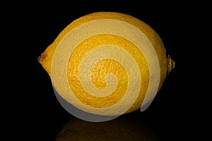 Fresh yellow lemon isolated on black glass