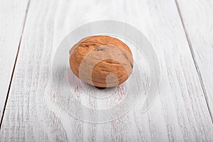 One whole walnut on wooden background, healthy brain food, walnut on light vintage table
