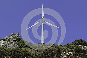 One windmill on the mountain. Blue sky background