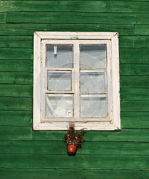 One window in vintage style in green wall background,architecture details. Colorful window fragment.Street scene with the house wi