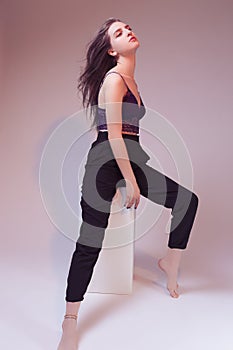 One Winsome Sexy Girl With Colorful Hair Style in Violet Nightie and Black Pants On Wooden Prop On Gray Background