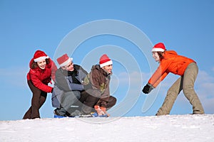 One woman pull two men on sled