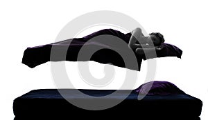 Woman sleeping in levitation on bed silhouette photo