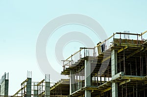 One worker working on the top of the building construction site with scaffold.