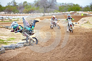 One wrong move and youre outta the race. A motocross rider taking a nosedive on the track.