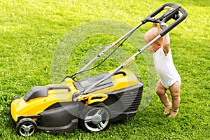 One year kid Grinding the grass with a grassmower