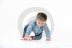 One year old Asian baby boy in jeans shurt sitting on floor play
