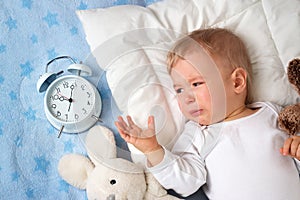 One year old baby with alarm clock