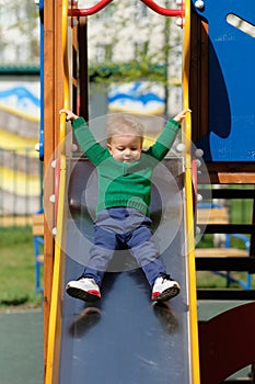 One year old baby boy toddler wearing green sweater at playground