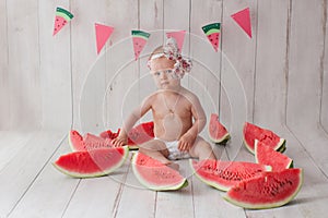 One year old baby girl takes a bath with watermelon.