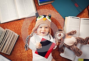 One year old baby reading books with teddy bear