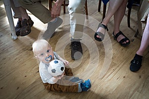 One year old boy with ball with adults