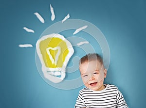 One year old boy and a bulb near. Child with an idea