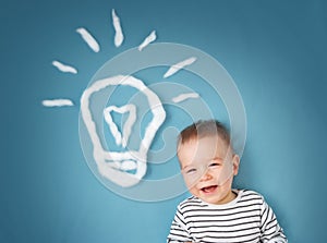 One year old boy and a bulb near. Child with an idea