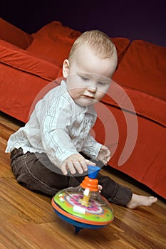 One year old boy playing with his spinning top.