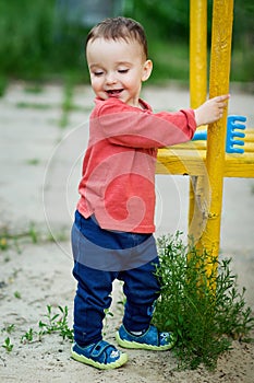 One-year-old boy is playing on a playground.