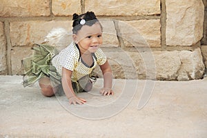 One year old crawling in a tutu