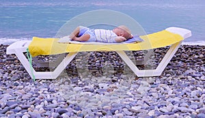 One year old newborn baby boy sleeping in the beach