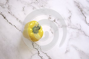 One Yellow Bell Pepper on a White Marble Background