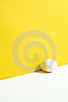 One yellow painted easter egg on yellow and white background
