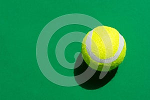 One yellow tennis ball laying on green court in bright sunlight sports active lifestyle competition victory concentration concept