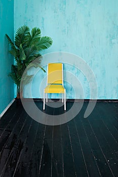 One yellow vintage chair in blue room interior