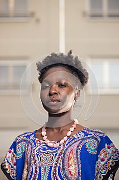 one, young adult, black african american woman, 20-29 years, serious expression, head and shoulders shot, buildings