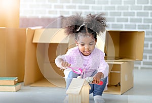 One young African american girls play toys and look fun and enjoy with paper box or carton as background . Concept of good