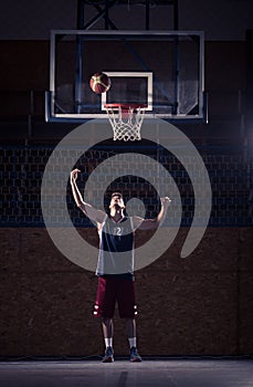 One young basketball player, shooting ball in air