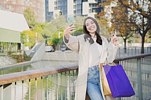 One young beautiful happy woman smiling doing a selfie portrait after shopping and sharing in the social media with a photo