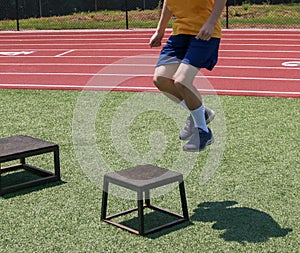 One young boy jumping ont to a small plyo box