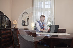 One young businessman working in his apartment room, antique furniture