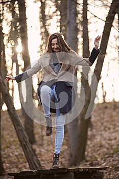 One young cute girl, standing on table with one leg, finding balance,