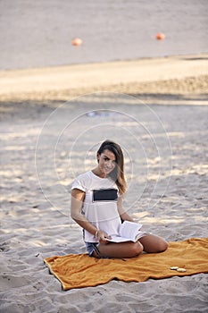 One young girl, relaxing reading a book outdoors, casual clothes, sunny day smiling