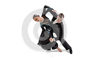 One young graceful artistic couple, man and woman dancing ballroom dance isolated over white studio background. Beauty
