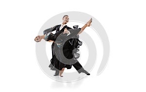 One young graceful artistic couple, man and woman dancing ballroom dance isolated over white studio background. Beauty