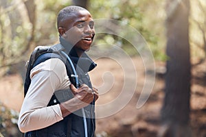 One young handsome african american male backpacker hiking outdoors in the woods. Confident and happy black man walking