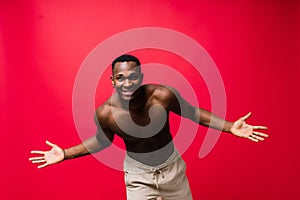 One young handsome african man topless portrait in studio on red background